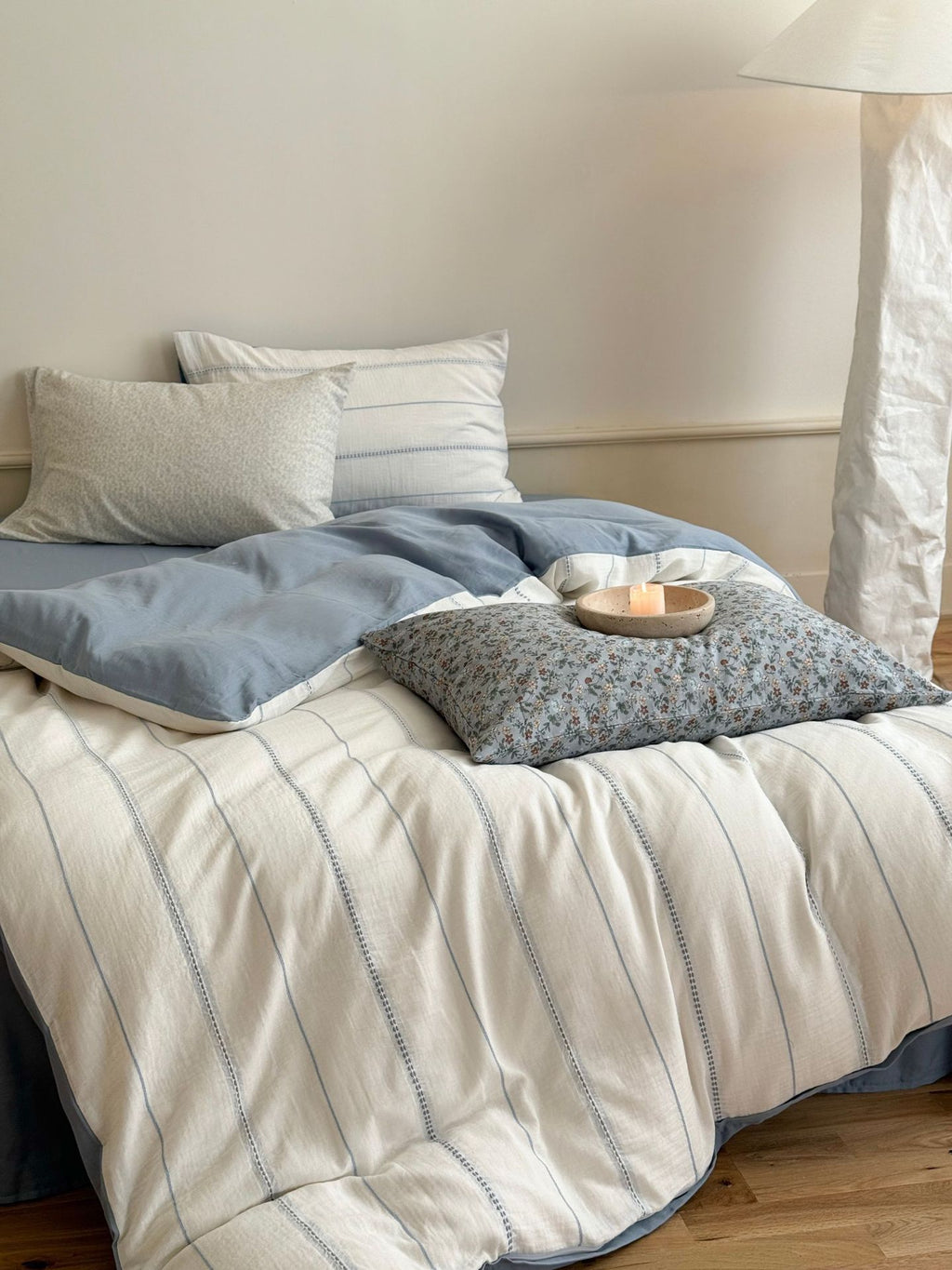 Bed with striped bedding and pillows in a bedroom setting