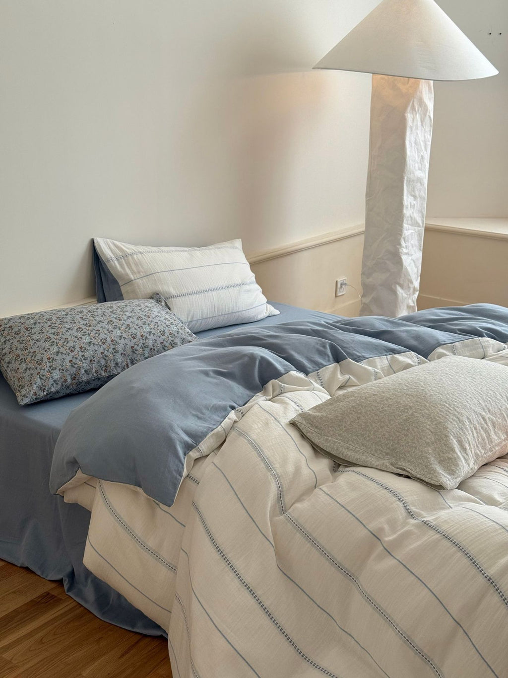 Bed with blue and beige bedding in a bedroom setting