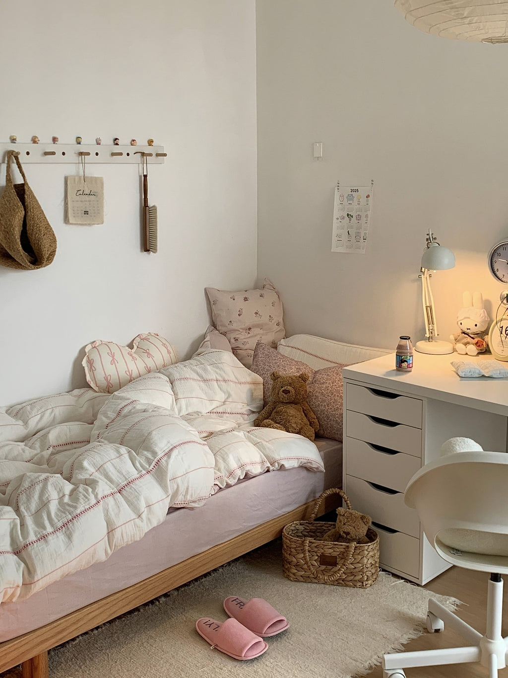 Cozy korea apartment bedroom with a pink stripes bedding, desk, and toys.