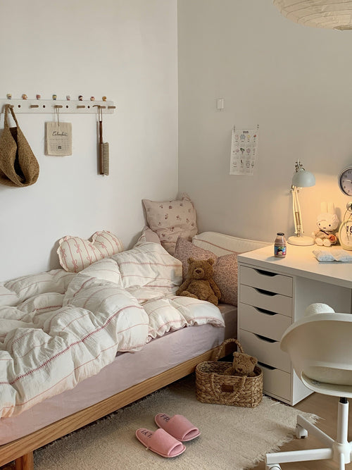 Cozy korea apartment bedroom with a pink stripes bedding, desk, and toys.