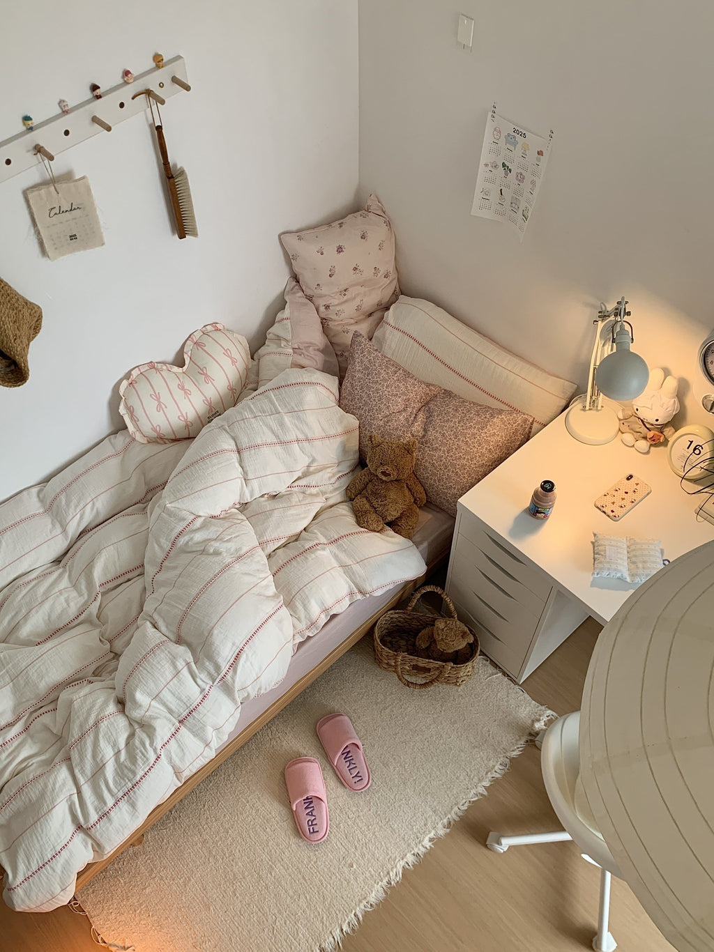 Cozy bedroom with a bed, pillows, and a nightstand with a lamp.