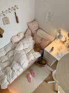 Cozy bedroom with a bed, pillows, and a nightstand with a lamp.