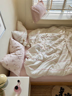 Bedroom with a bed, pillows, and a nightstand.